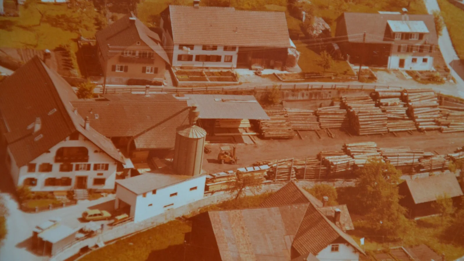 Luftbild von 1980 mit dem Sägewerk am alten Standort, dicht umbaut von Wohnhäusern und Wirtschaftsgebäuden